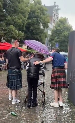 Scottish fans sheltering an old man from the rain is immortalised on German trains after Mail Sport’s video of the wholesome moment went viral on social media